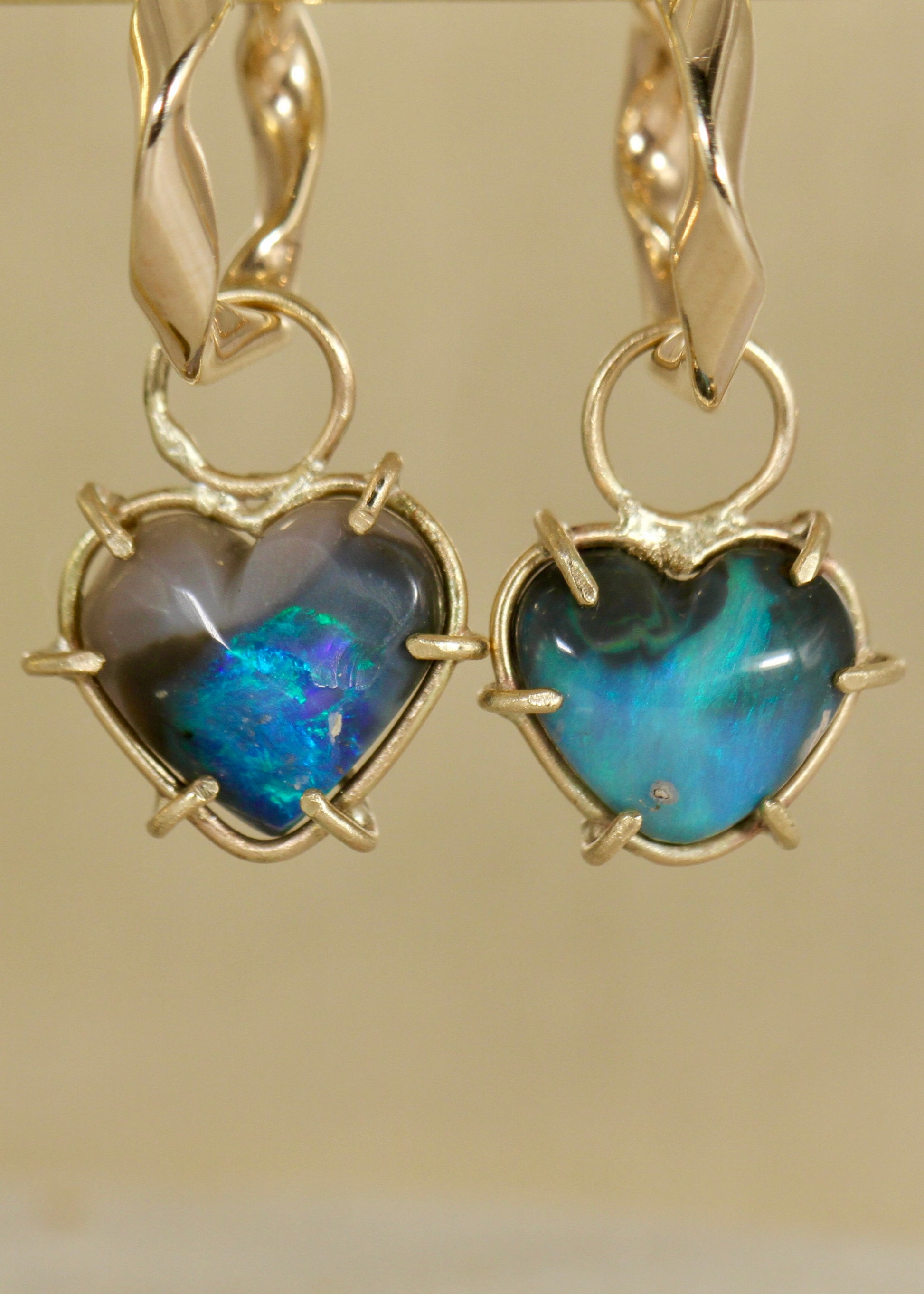 Black Opal Blue Heart earring charms in solid 9ct gold hanging on a pair of slight twist 9ct gold earrings (front view)