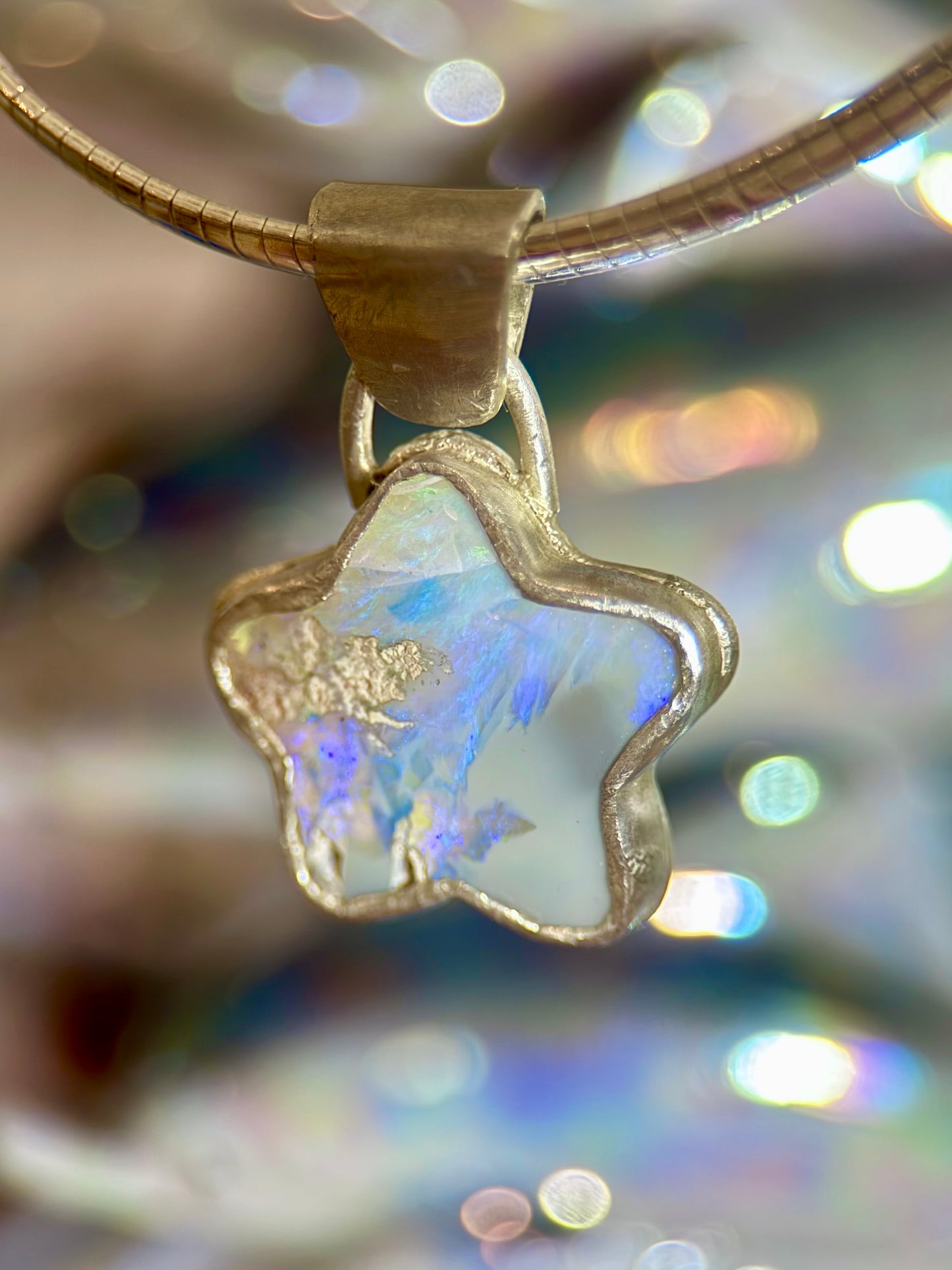 Star Opal pendant with silver setting on a blurred background